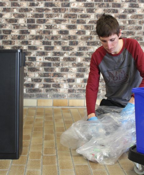 Éleve en train de trier des déchets à l'école Serge Bouchard