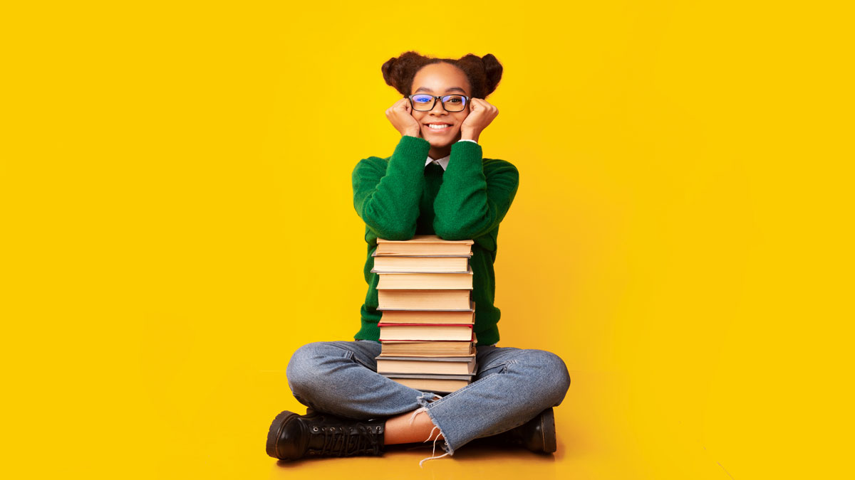 Adolescente assise devant une pile de livres