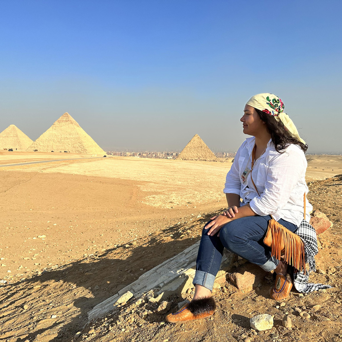Femme assise devant les pyramides en Égypte