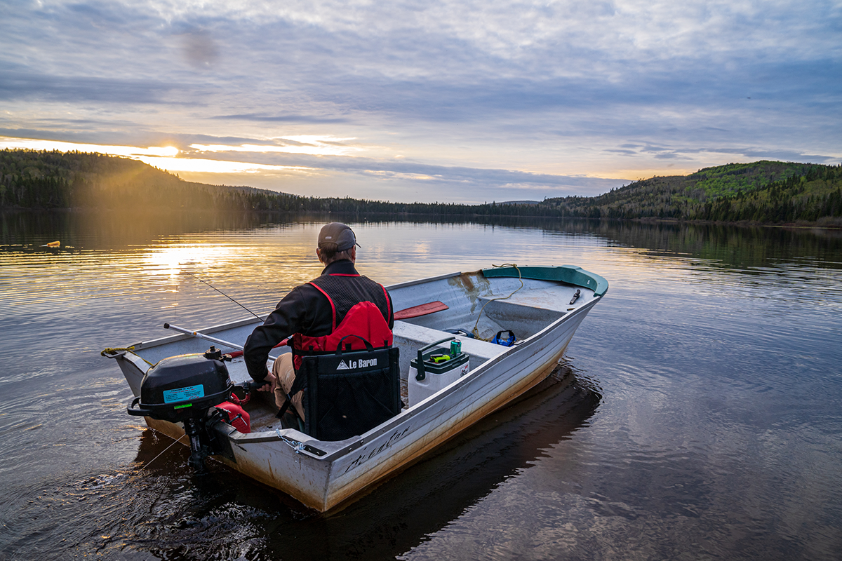 Pêcheur sur une barque au coucher du soleil